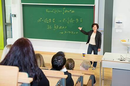 Foto: Eine Dozentin hält eine Vorlesung vor Studierenden in einem Hörsaal