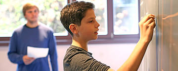 Ein Junge schreibt an die Tafel (Foto: Freie Hochschule Stuttgart)
