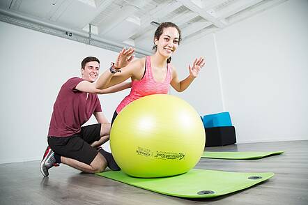 Zwei Personen bei einer Physiotherapieanwendung mit Gymnastikball
